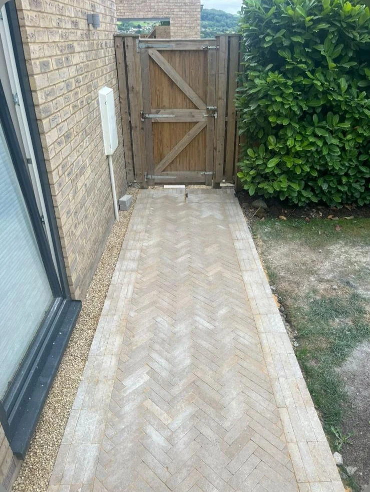 Herringbone block paving pathway with timber gate