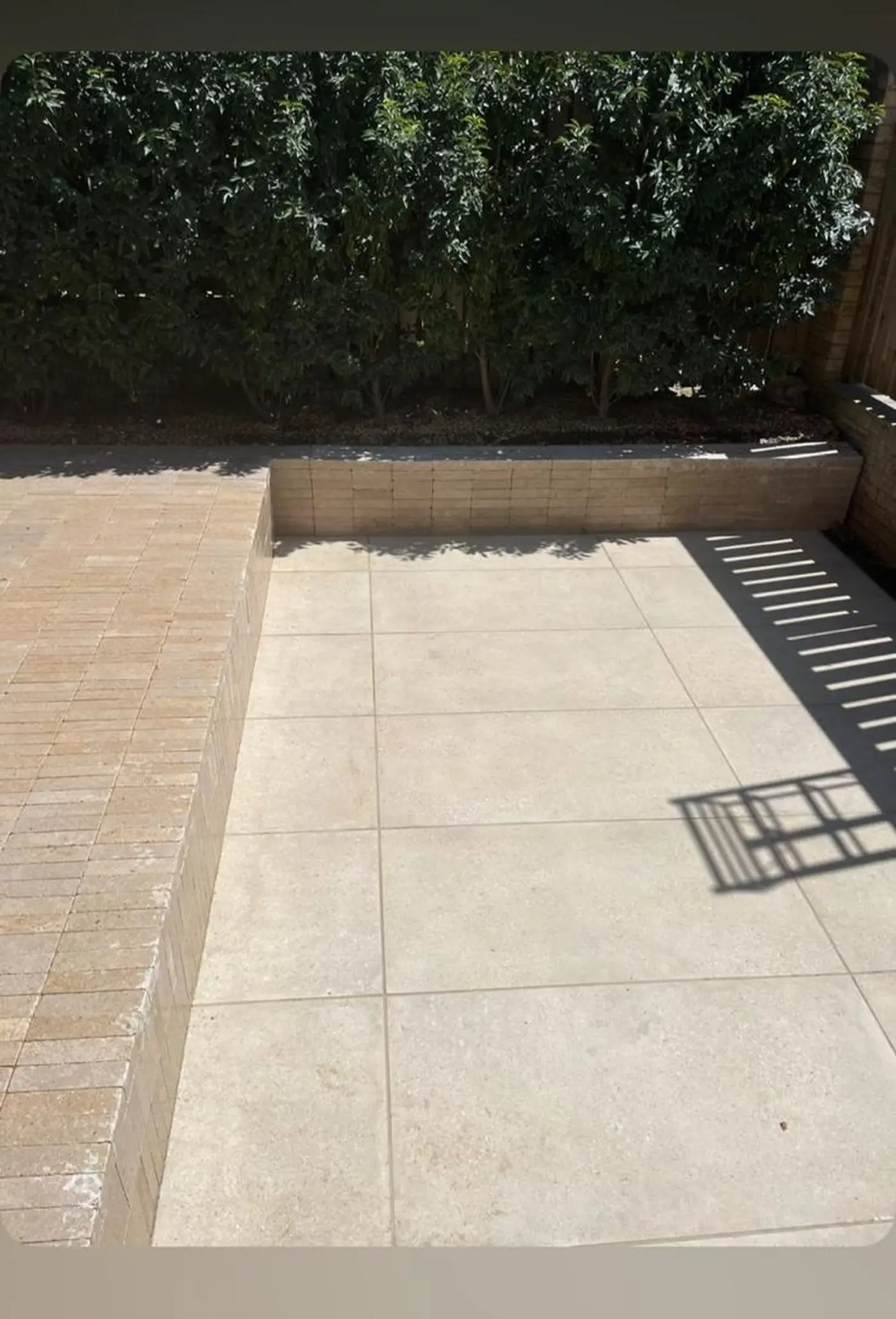 Sandstone patio with hedge backdrop